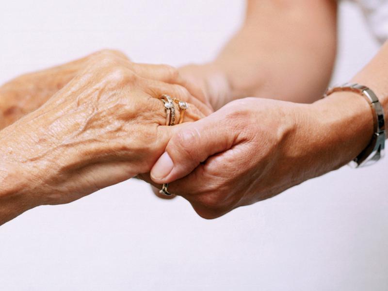 Patient holding hands with a nurse