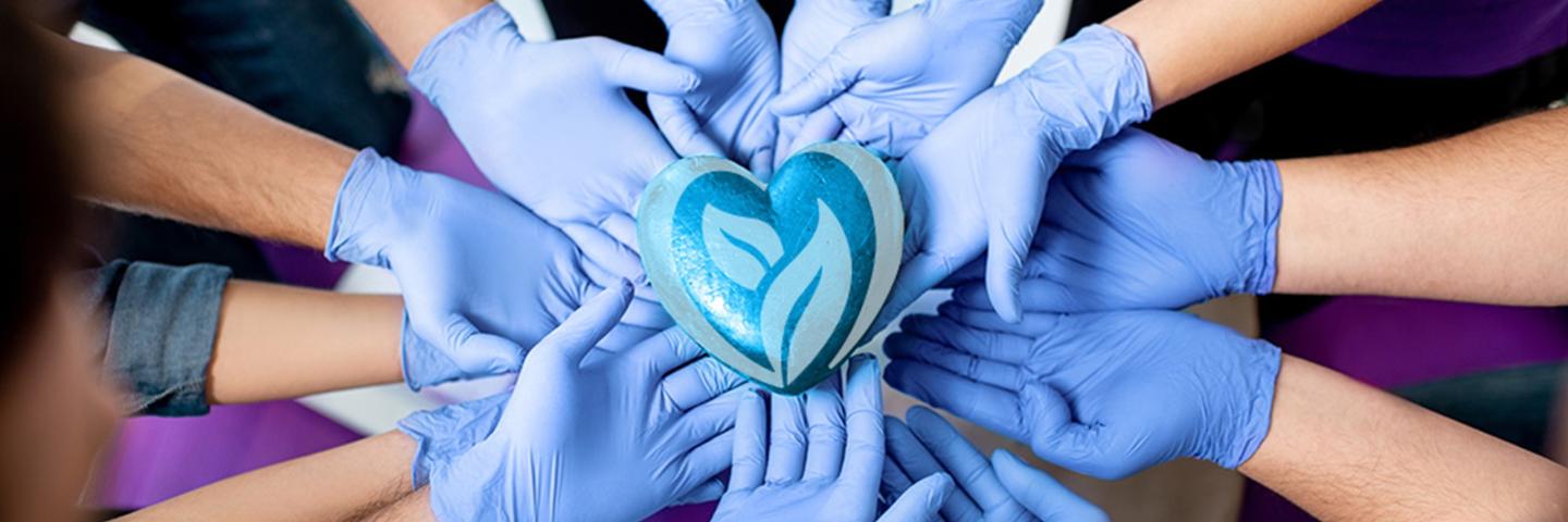 Gloved hands holding heart logo