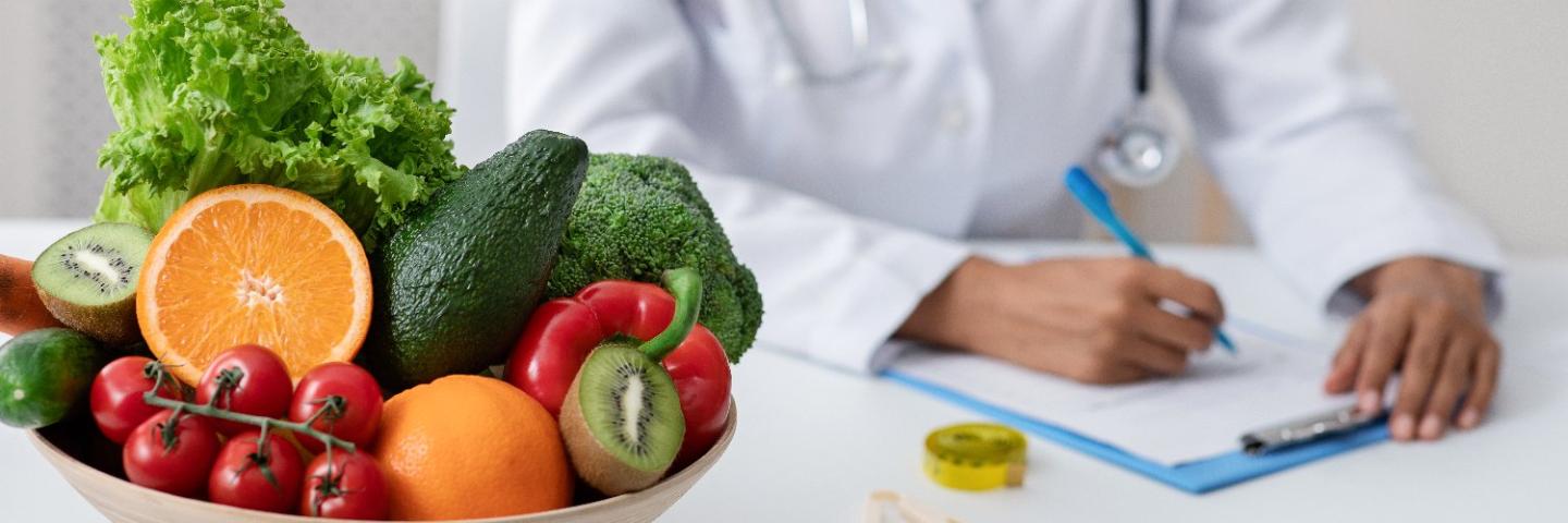 Closeup of Nutritionist's hands with bowl of fruite and vegetables