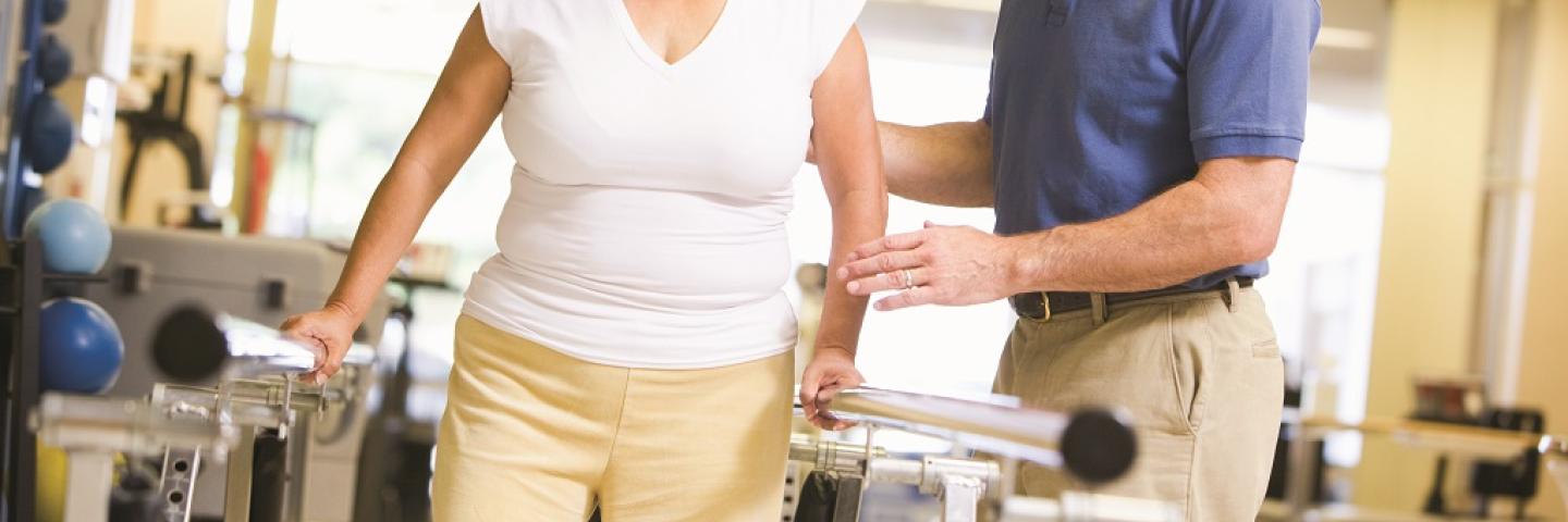 Physical Therapist assisting a woman during PT