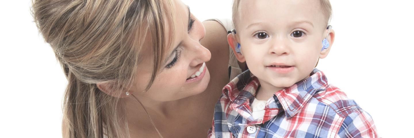 Therapist with young boy with hearing aids 